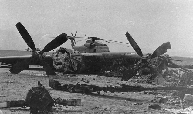 Burned wreckage of US Air Force EC-130, with an abandoned Sea Stallion behind (Author unknown)